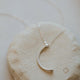 A silver statement necklace with a moon pendant handmade by Hello Adorn in the Mini-Moon Pendant style.