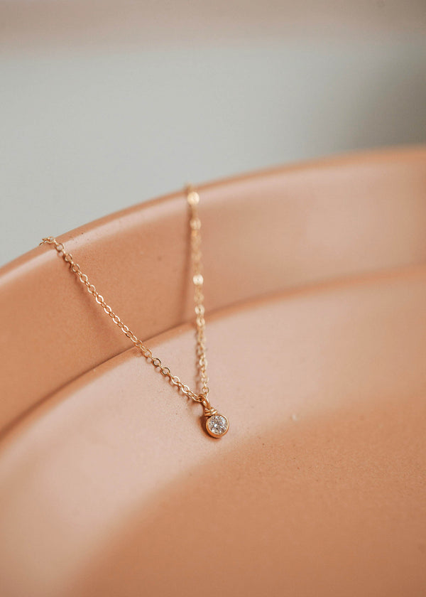 A gold simple necklace designs with a bezel setting necklace diamond handmade from Hello Adorn in the Solitaire Necklace design, a minimalist necklace for daily wear jewelry.