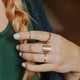 Wondering how to stack rings on fingers? Hello Adorn created this gold ring stack using stacking rings and a statement ring with an above the knuckle ring, flat ring, hammered ring in Confetti Ring style, thin ring, and a circle ring hammered to look like a moon ring.