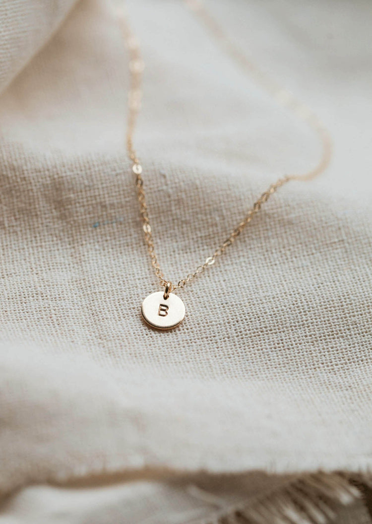 Tiny initial necklace that is hand stamped jewelry by Hello Adorn.