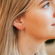 Circle stud earrings styled with gold ear cuff and annex studs in an ear by Hello Adorn.