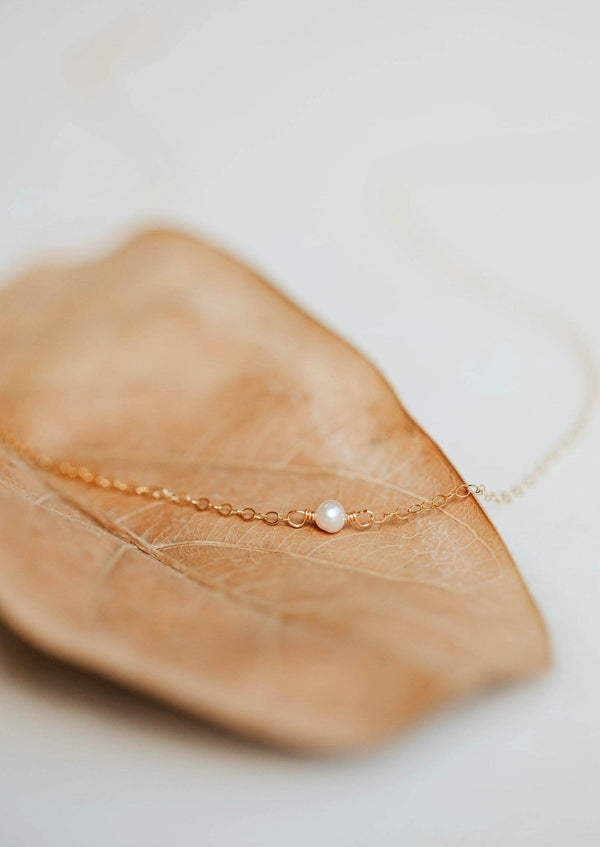 A freshwater pearl necklace created by Hello Adorn as a delicate necklace in the Tiny Freshwater Pearl Necklace style.