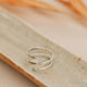 A silver statement ring that looks like 2 rings, but is only one wire wrapped ring using thicker wire to create the Wrap Ring by Hello Adorn.